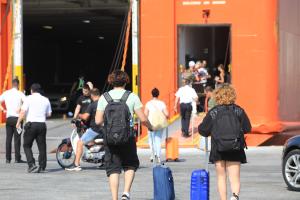 Άνθρωποι με βαλίτσες μπαίνουν σε πλοίο