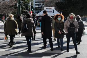 Άνθρωποι με μάσκα περπατούν στο δρόμο
