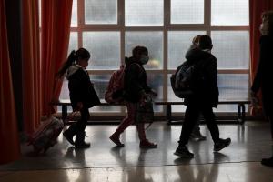 Παιδιά με τσάντες σε διάδρομο σχολείου μπροστά από παράθυρο