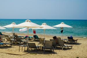 Ξαπλώστρες με ομπρέλες μπροστά στην θάλασσα