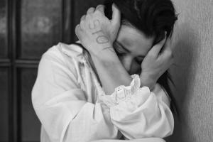 Γυναίκα προστατεύει το κεφάλι της με τα χέρια