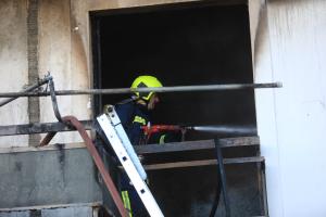 Πυροσβέστης σβήνει φωτιά σε διαμέρισμα