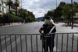 Γυναίκα αστυνομικός μπροστά από κάγκελα που κόβουν την κυκλοφορία