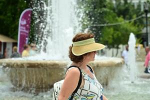 Γυναίκα περπατά μπροστά από σιντριβάνι