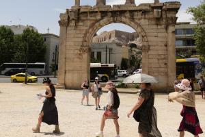 Άνθρωποι περπατούν εν μέσω καύσωνα στην Αθήνα