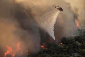 Πυροσβεστικό ελικόπτερο ρίχνει νερό στη φωτιά