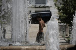 Αγόρι δροσίζεται στο συντριβάνι της πλατείας Συντάγματος εν μέσω καύσωνα