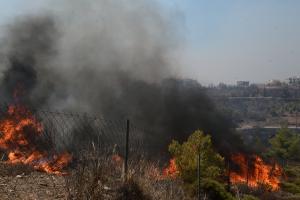 Φωτιά καίει χόρτα πίσω από συρμάτινο φράχτη