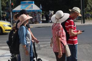 Κόσμος περιμένει στο φανάρι στην πλατεία Συντάγματος