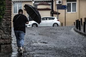 Άνδρας περπατά στη βροχή στη Θεσσαλονίκη