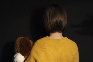 Κοριτσάκι γυρισμένο πλάτη με αρκουδάκι στα χέρια