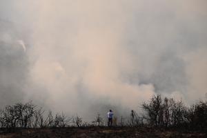 Πυκνός καπνός από την φωτιά στο Ξυλόκαστρο και μπροστά άνθρωπος που τραβά φωτογραφία