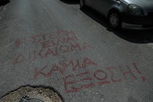 Σύνθημα κατά των πλειστηριασμών γραμμένο σε δρόμο