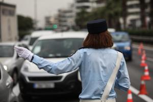 Τροχονόμος σε δρόμο και πίσω αυτοκίνητα