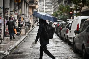 Κοπέλα με ομπρέλα στη βροχή στο κέντρο της Αθήνας
