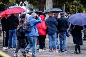 Κόσμος με μπουφάν και ομπρέλες στον δρόμο