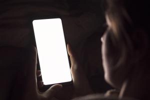 Γυναίκα κοιτάζει την οθόνη κινητού τηλεφώνου