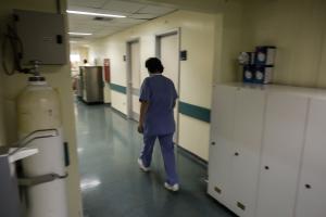 Νοσηλεύτρια περπατά σε διάδρομο νοσοκομείου