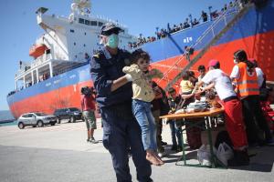Λιμενικός με παιδί προσφύγων στα χέρια
