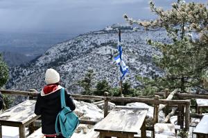 Άνθρωπος κοιτάει την χιονισμένη Πάρνηθα