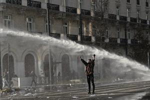 Διαδηλώτρια ενώ η αύρα ρίχνει νερό