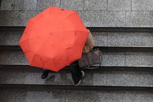 Άνθρωπος με ομπρέλα ανεβαίνει σκαλιά