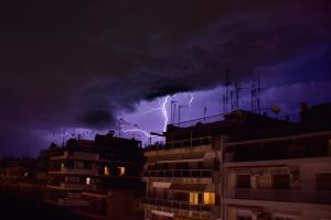 Κεραυνοί και σύννεφα πάνω από αστικό τοπίο