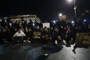 Διαδηλωτές σε καθιστική διαμαρτυρία στο Σύνταγμα τραγουδούν με τη συνοδεία κιθάρας