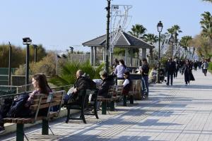Άνθρωποι που περπατούν και που κάθονται σε παγκάκια