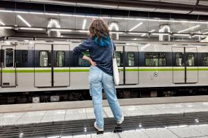 Συρμός σε αποβάθρα σταθμού μετρό και επιβάτιδα που περιμένει