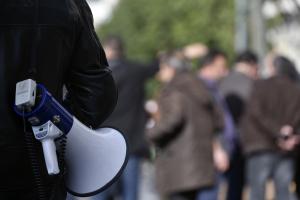 Άντρας κρατά ντουντούκα στον ώμο σε απεργιακή συγκέντρωση