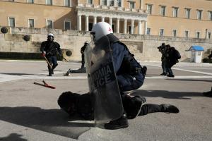 Άντρας των ΜΑΤ κρατά διαδηλωτή στο πάτωμα μπροστά από τη Βουλή