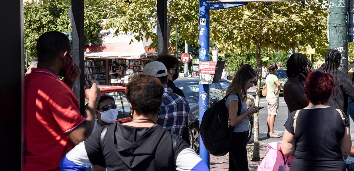 Κόσμος περιμένει να έρθει το λεωφορείο