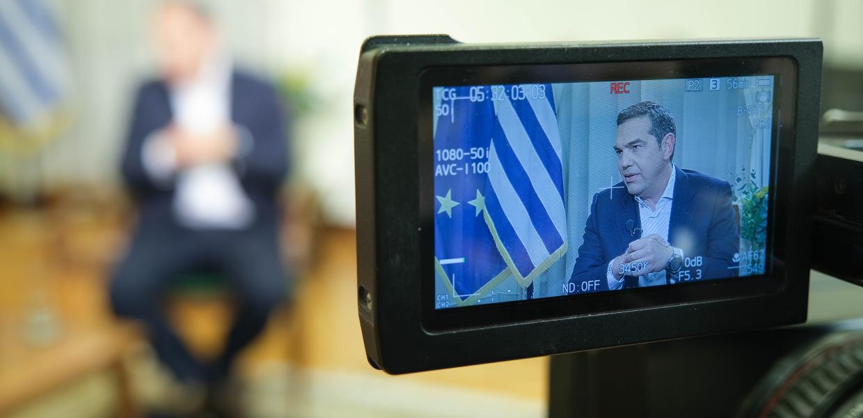 Κάμερα και στο βάθος ο Αλέξης Τσίπρας
