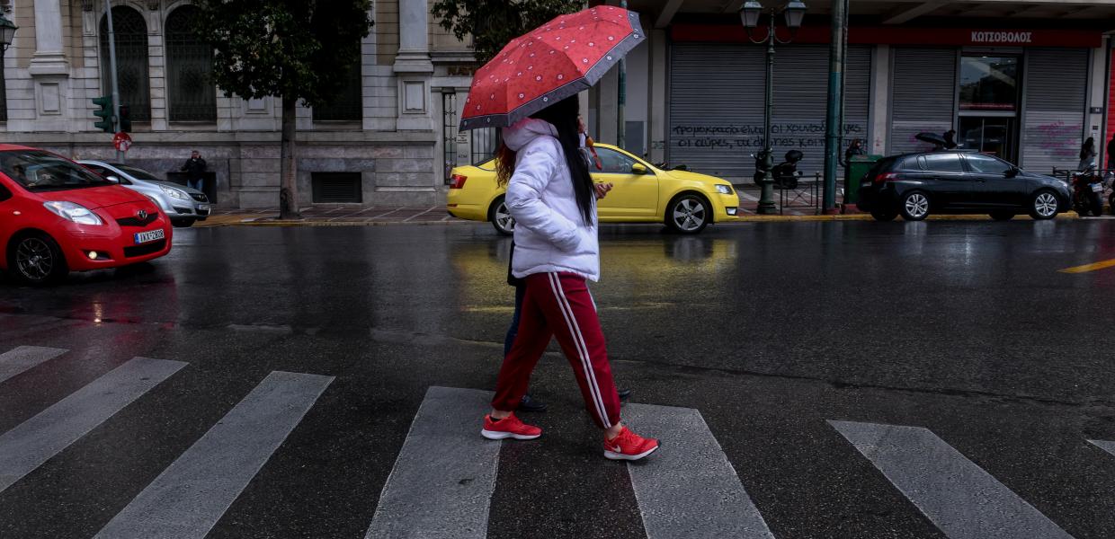 Γυναίκα με ομπρέλα στο κέντρο της Αθήνας εν μέσω lockdown