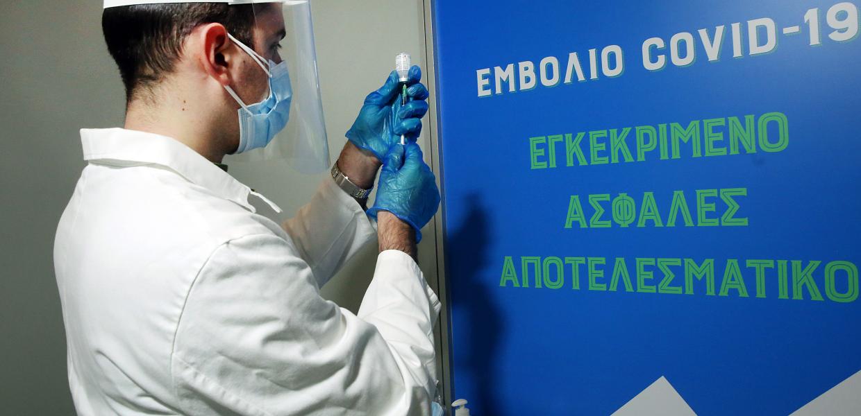 Γιατρός προετοιμάζεται να εμβολιάσει πολίτη