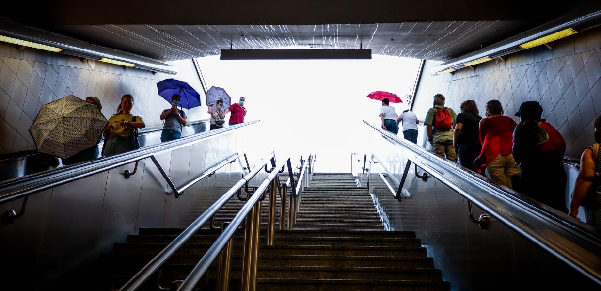 Κόσμος σε κυλιόμενες σκάλες στο μετρό