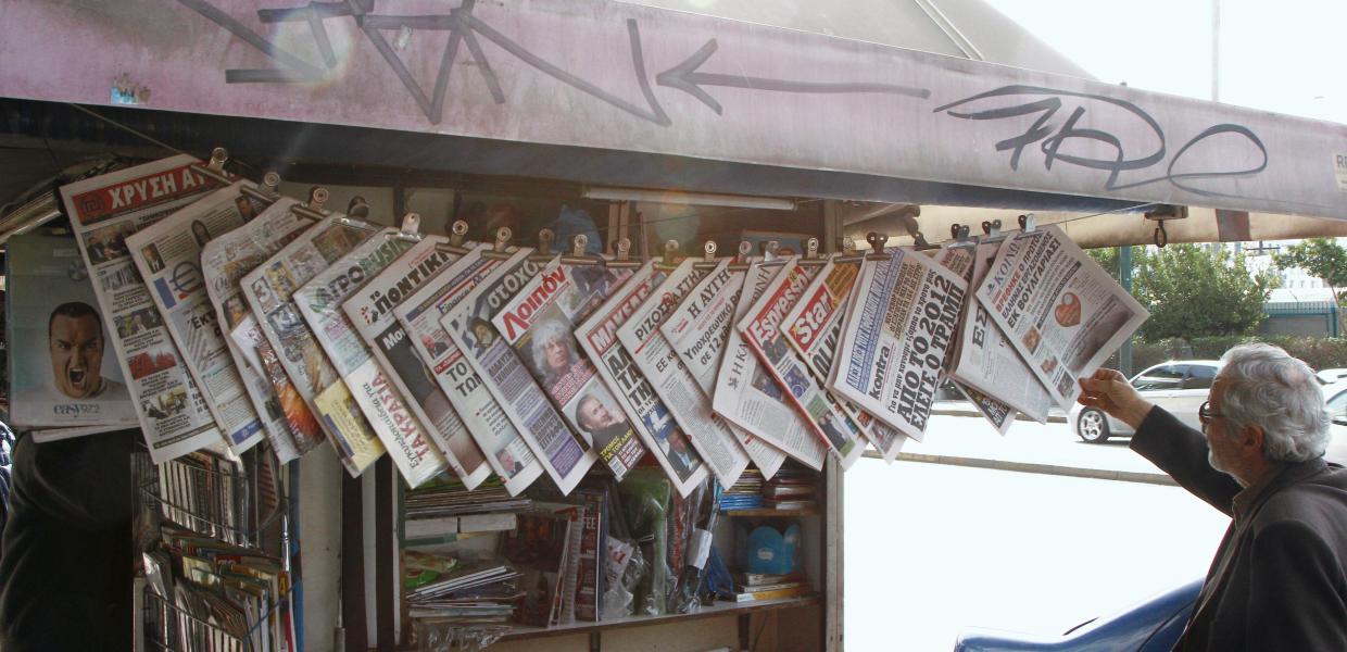 Εφημερίδες κρεμασμένες σε περίπτερο