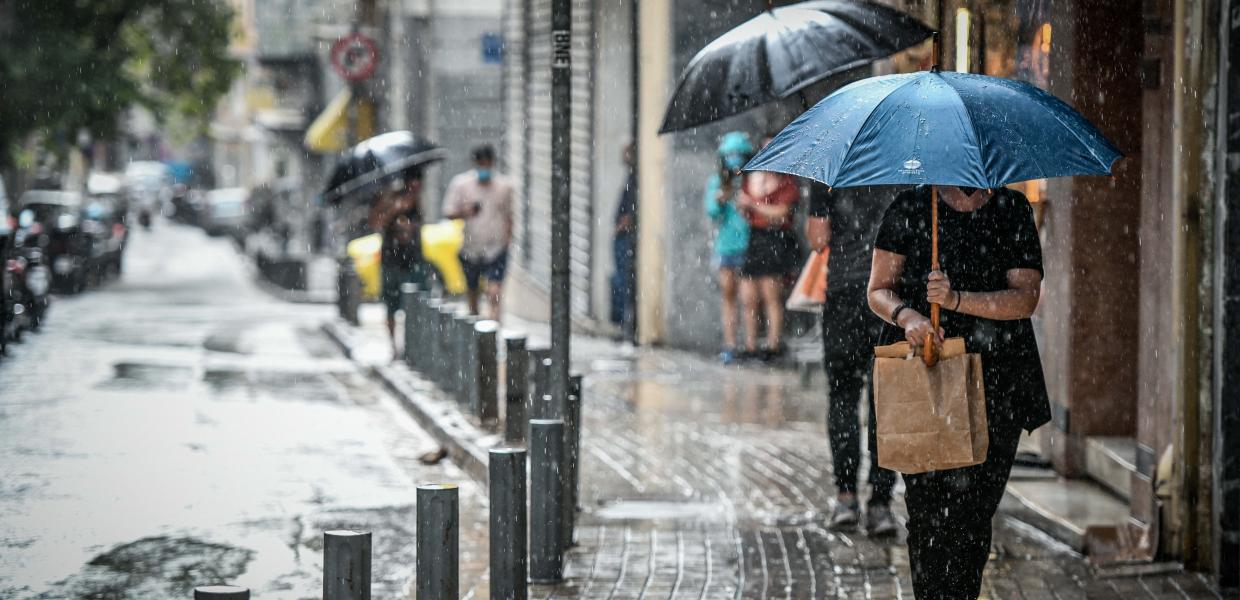 Κόσμος με ομπρέλες λόγω βροχής