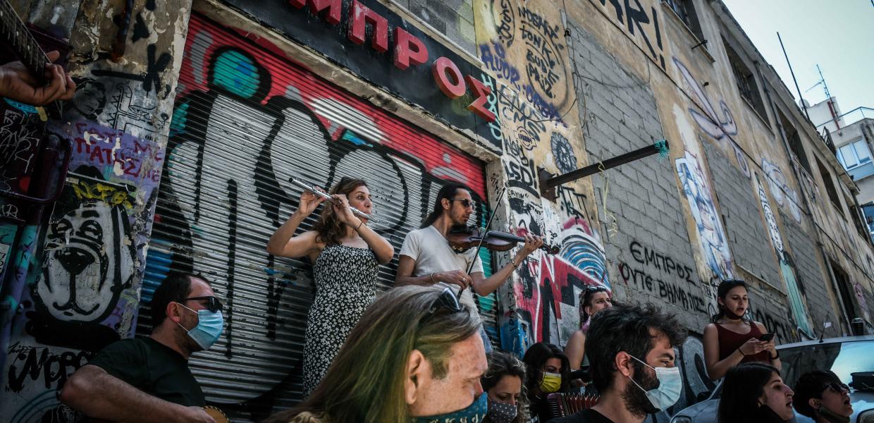 Η ομάδα «Τραγούδι Μήνυμα Αντίστασης» σε μουσική εκδήλωση μπροστά στη σφραγισμένη είσοδο του θεάτρου «ΕΜΠΡΟΣ», 26 Μαΐου 2021. 