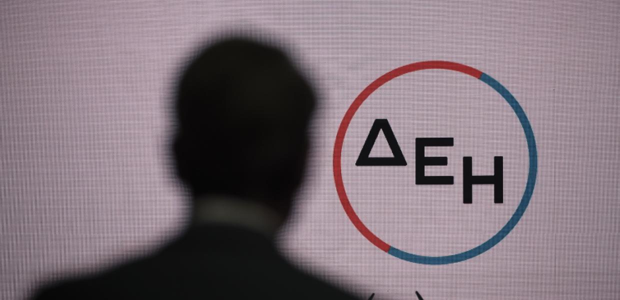 Ο Κυριάκος Μητσοτάκης και στο βάθος το σήμα της ΔΕΗ