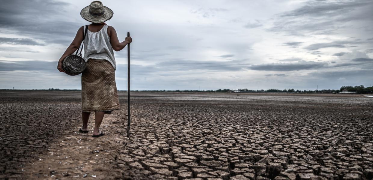 Γυναίκα κοιτάζει εδάφη με ξηρασία