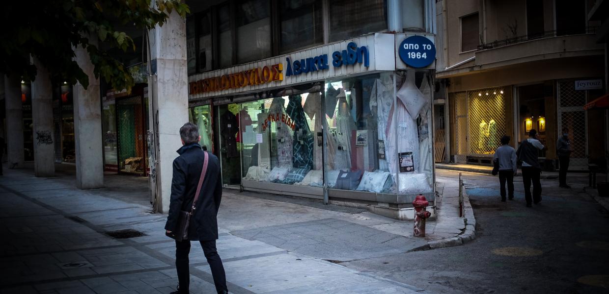 Άνθρωπος μπροστά σε μαγαζί στο κέντρο της Αθήνας