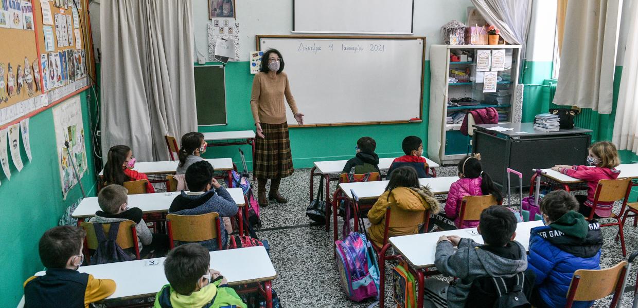 Μαθητές και δασκάλα σε τάξη δημοτικού σχολείου