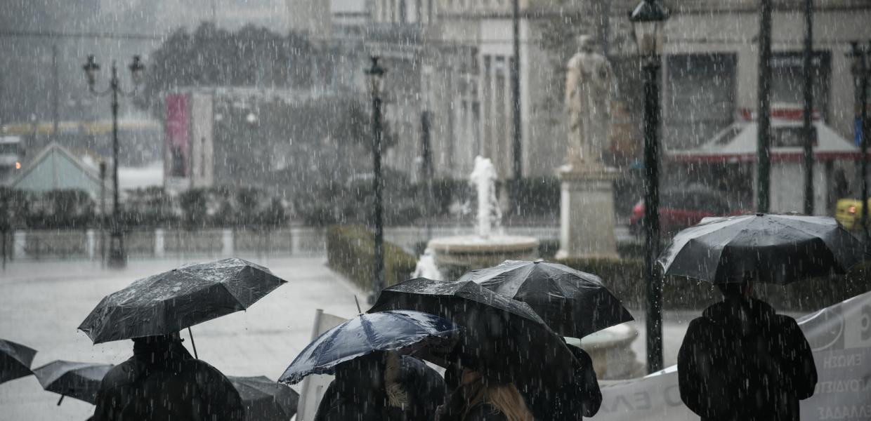 Άνθρωποι με ομπρέλες υπό βροχή
