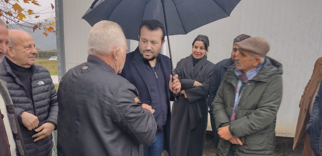 Ο Νίκος Παππάς μιλάει ανθρώπους μπροστά σε οικίσκους
