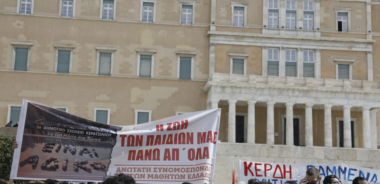 Κόσμος σε συγκέντρωση με πανό μπροστά στη Βουλή