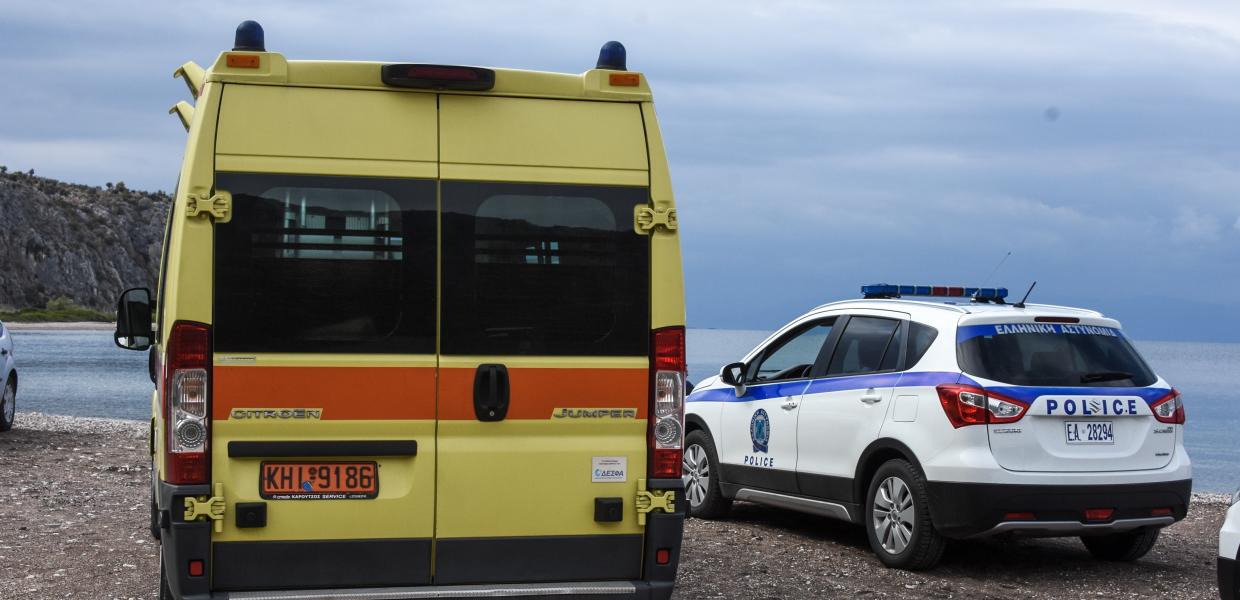 Ασθενοφόρο δίπλα σε περιπολικό της αστυνομίας μπροστά στη θάλασσα 