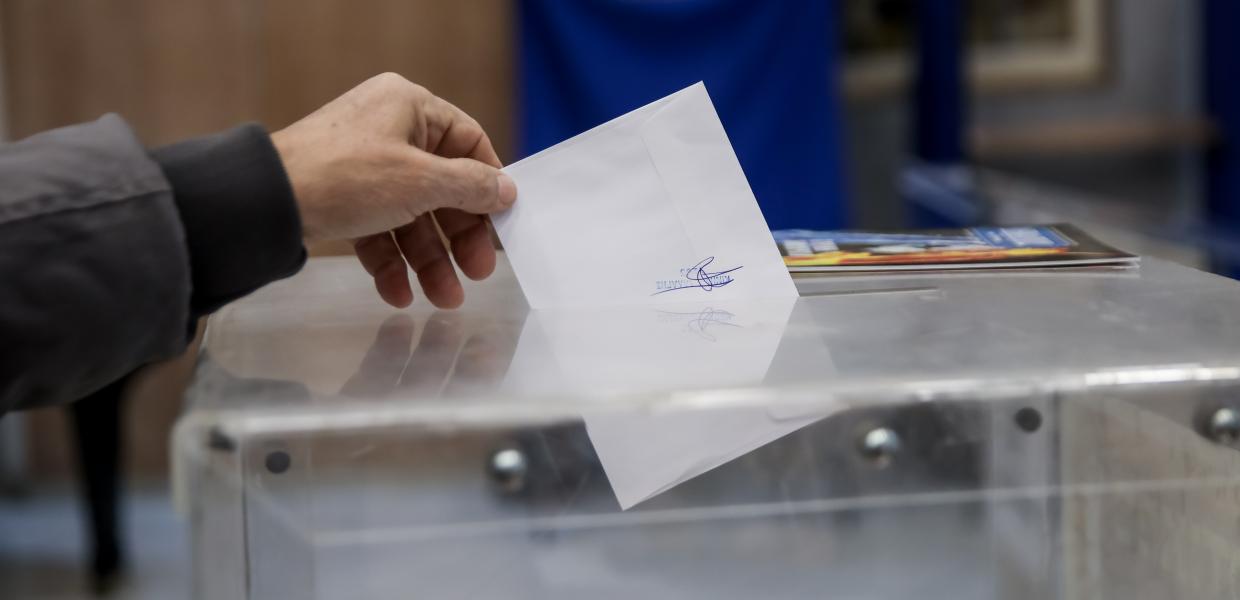 Άνθρωπος βάζει τον φάκελο στη εκλογική κάλπη