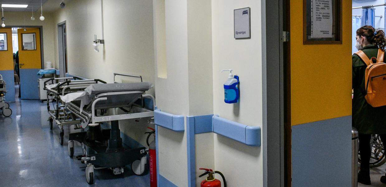 Διάδρομος νοσοκομείο με ράντζο και μια επισκέπτης που φαίνεται μέσα σε θάλαμο